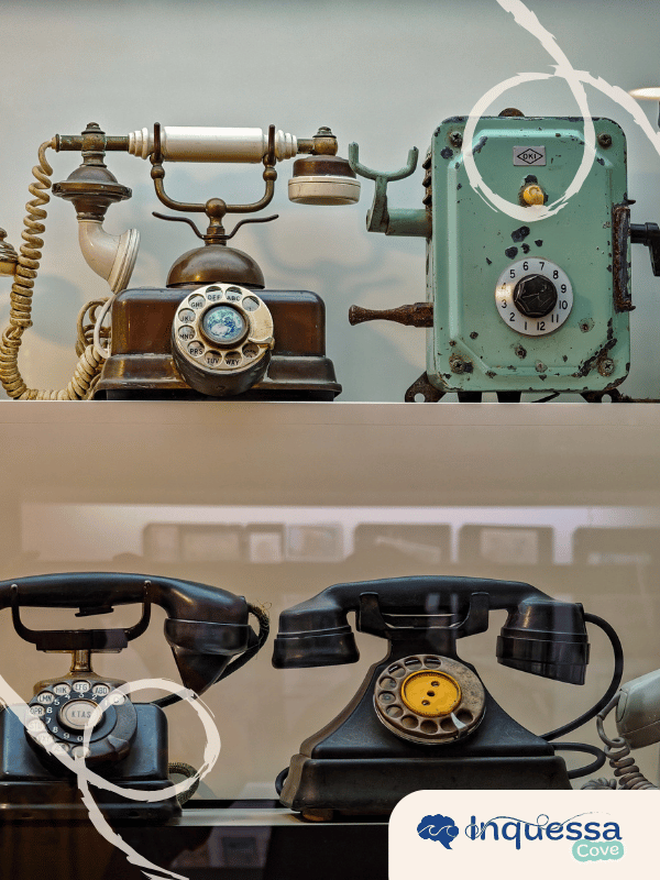 Several vintage rotary telephones displayed on shelves