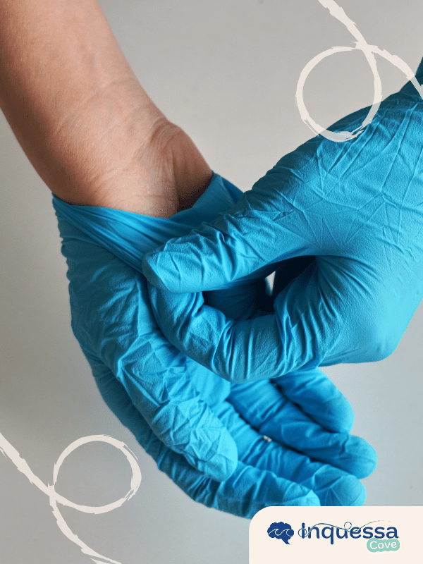 Person pulling on a pair of blue disposable gloves