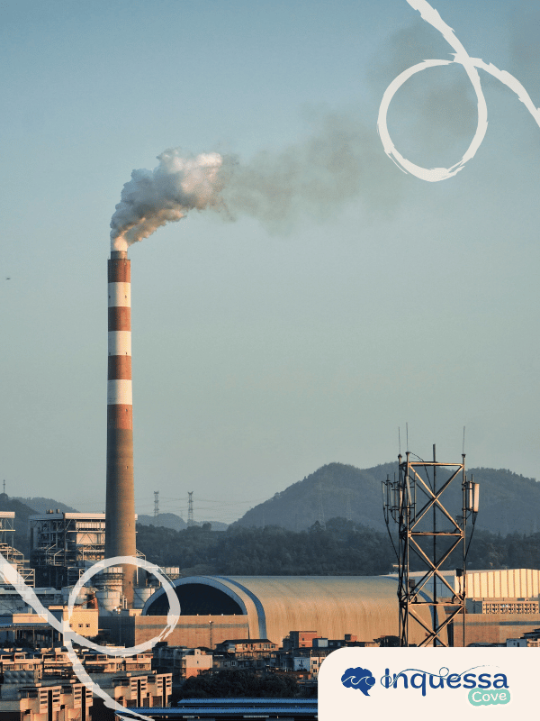 Industrial smokestack releasing smoke above a factory