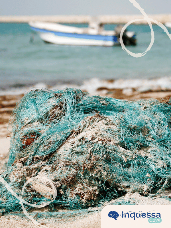 Tangled fishing net washed up on a sandy beach near the water