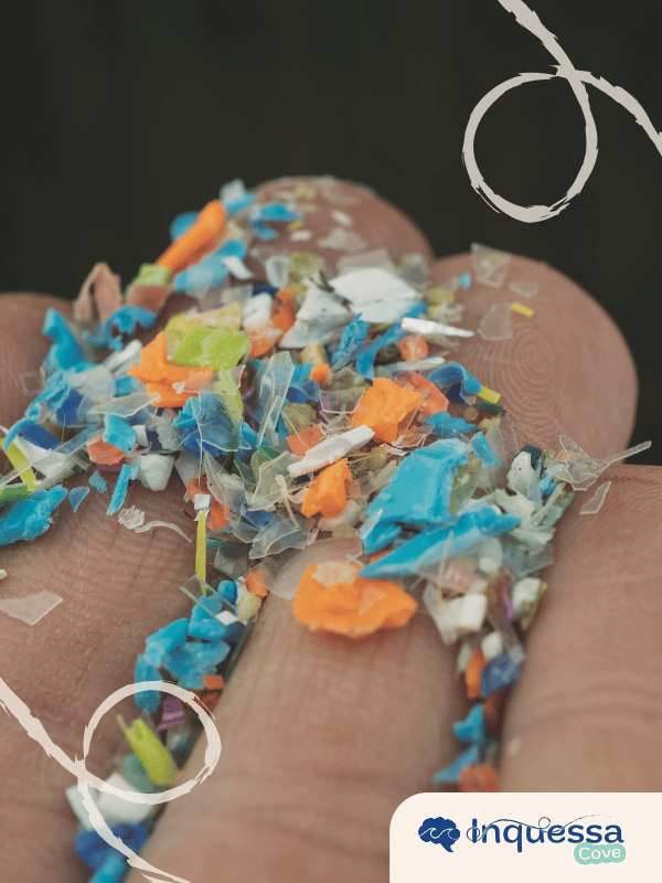 Tiny colorful plastic fragments resting across a person’s fingertips