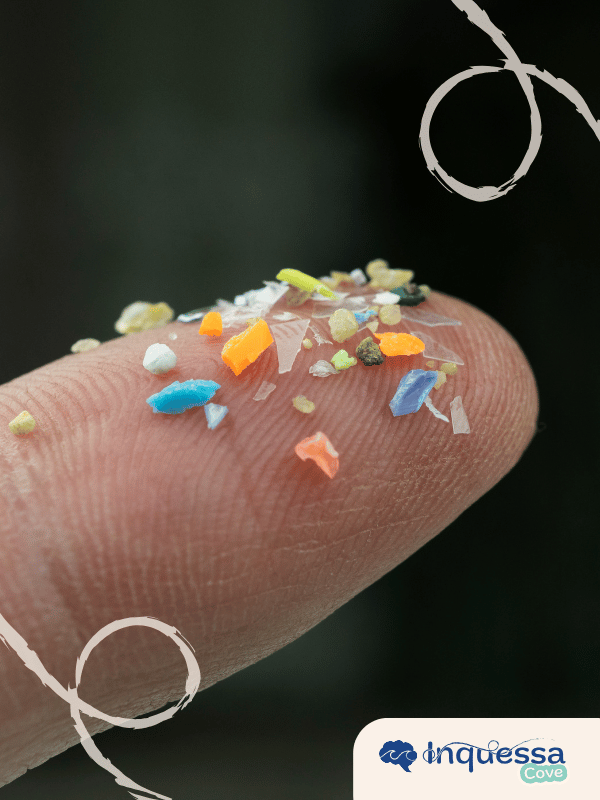 Tiny pieces of colorful plastic resting on the tip of a finger