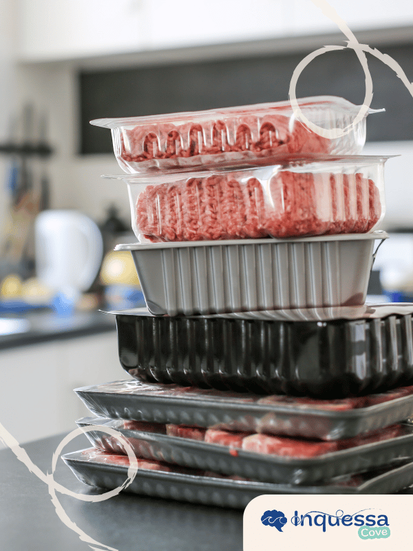 Stacks of raw meat packaged in plastic trays and clear wrapping