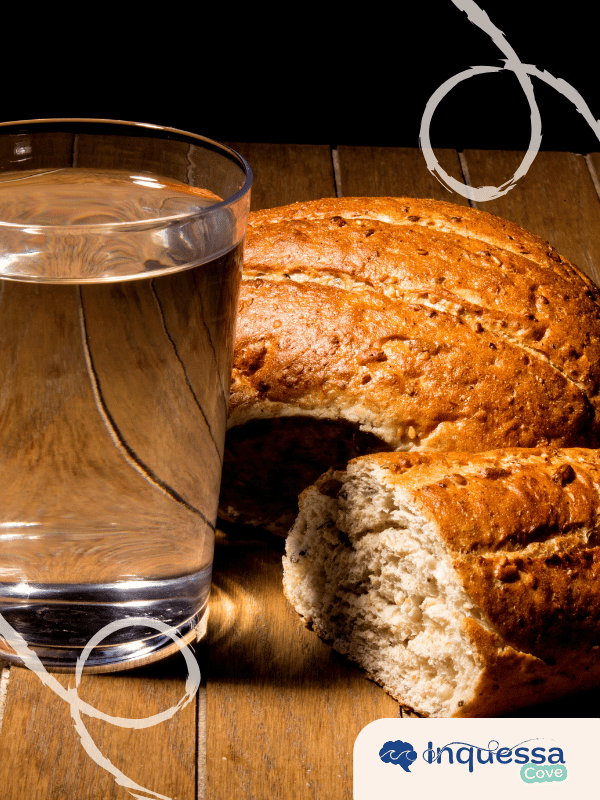 Glass of water beside slices of whole grain bread