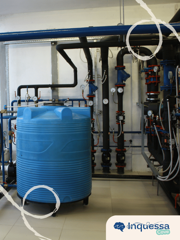 Blue water storage tank and pipes inside an industrial facility